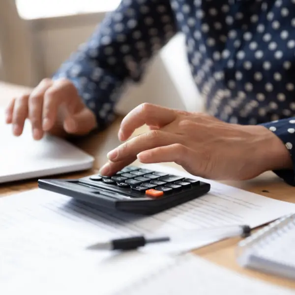 Person using a calculator with their left hand