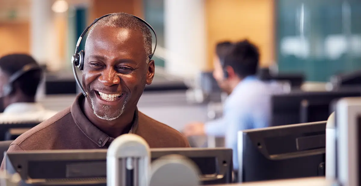 Man smiling while sat in office with headset on