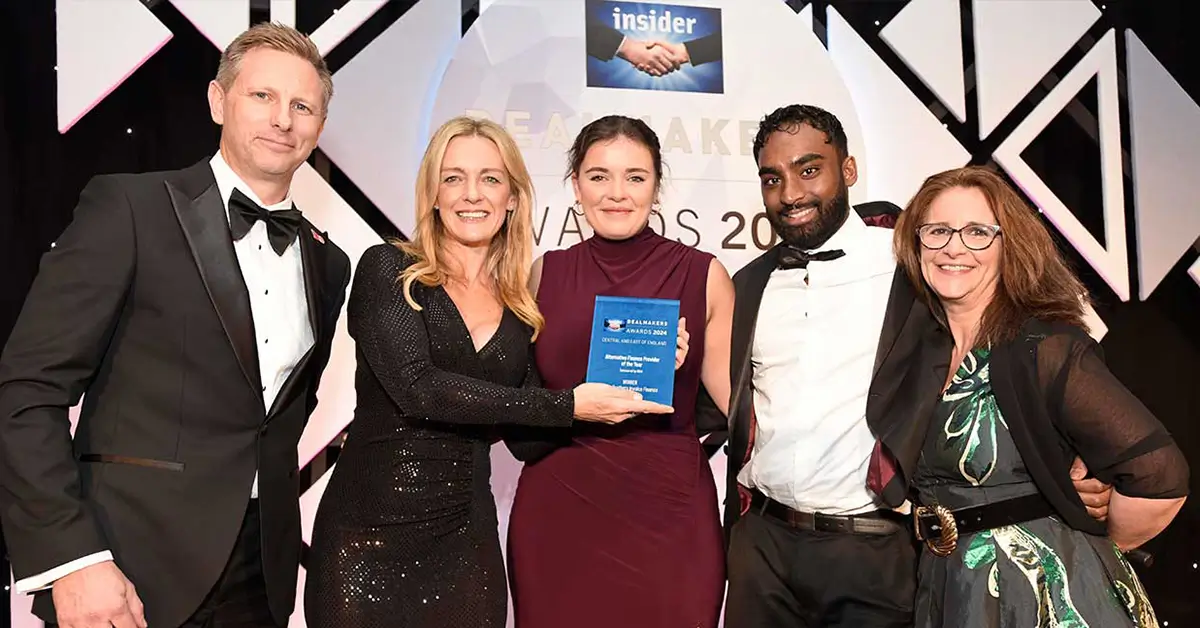 Group of three women and two men posing for an award photo