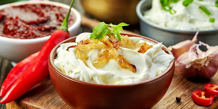 Hummus in bowls with chili pepper on the side